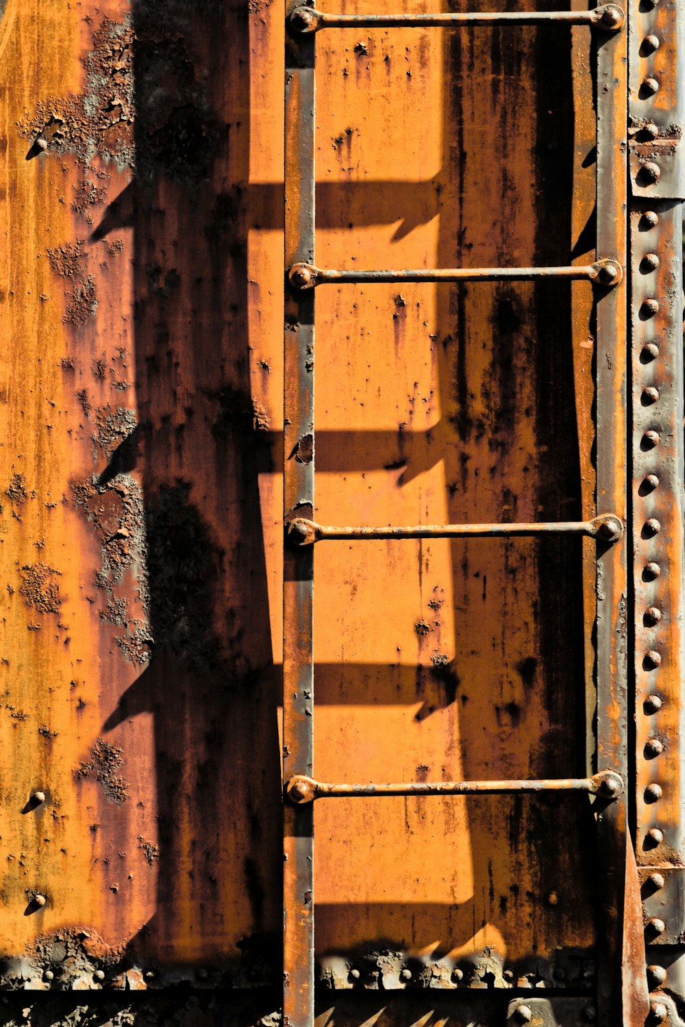 a close up of a rusted metal structure with rivets