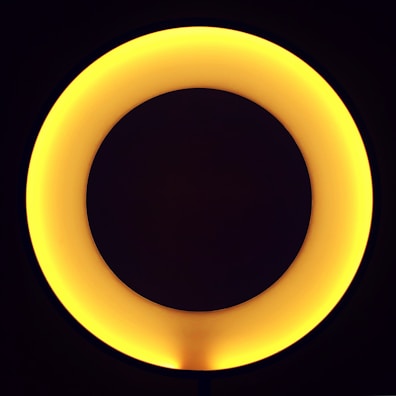 A glowing ouroboros encircling a radiant golden sun against a deep purple background.