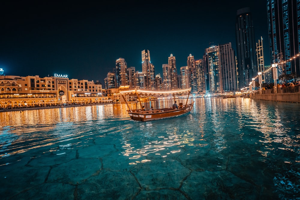 a boat floating on top of a river next to tall buildings