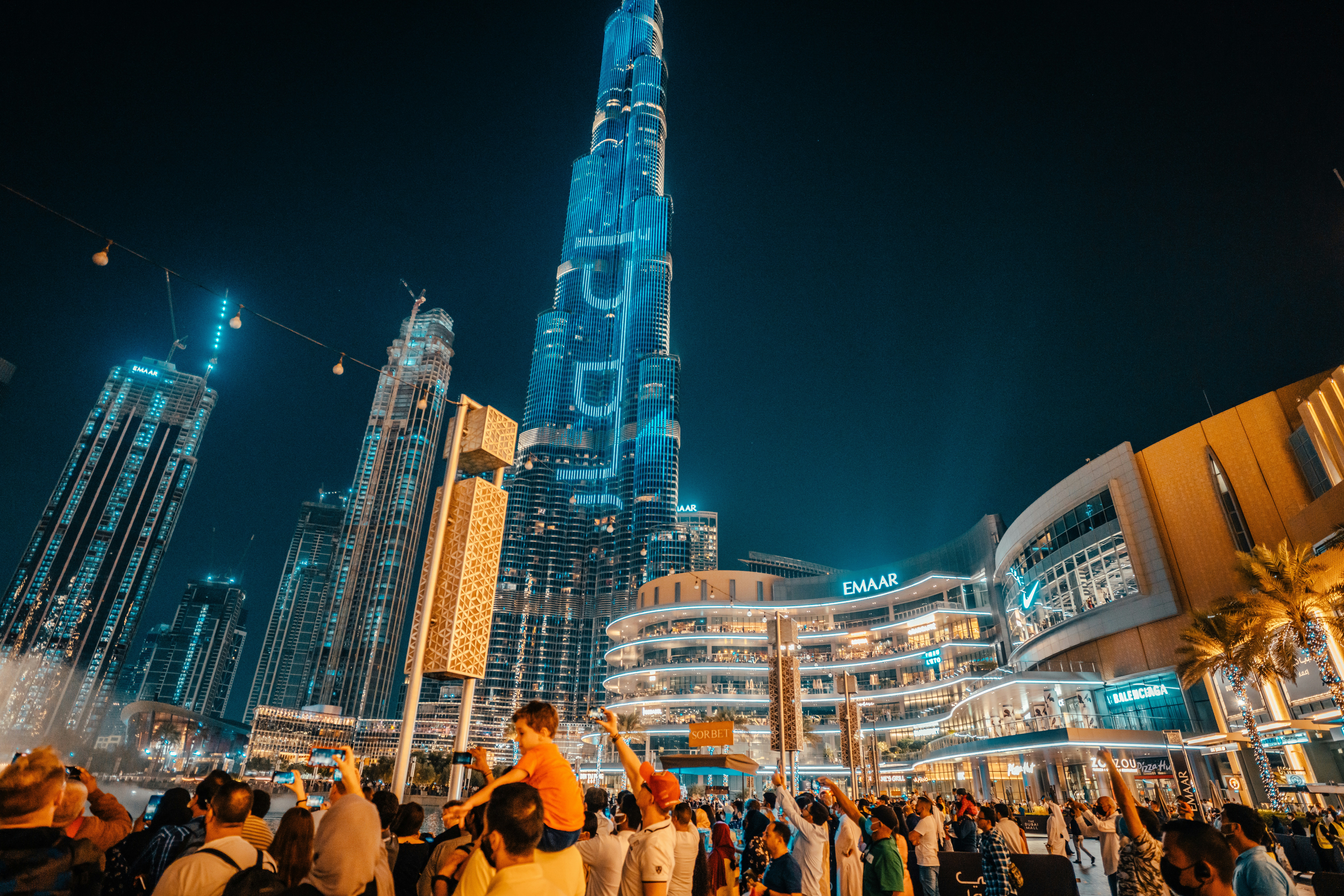 a crowd of people standing around a tall building