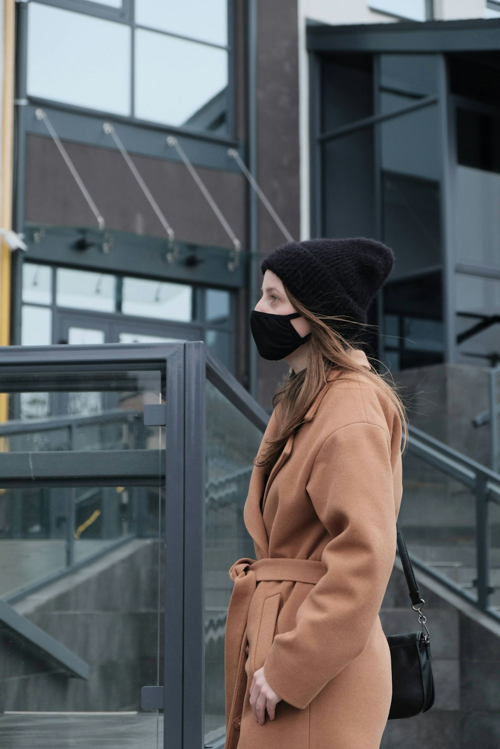 a woman wearing a face mask and coat