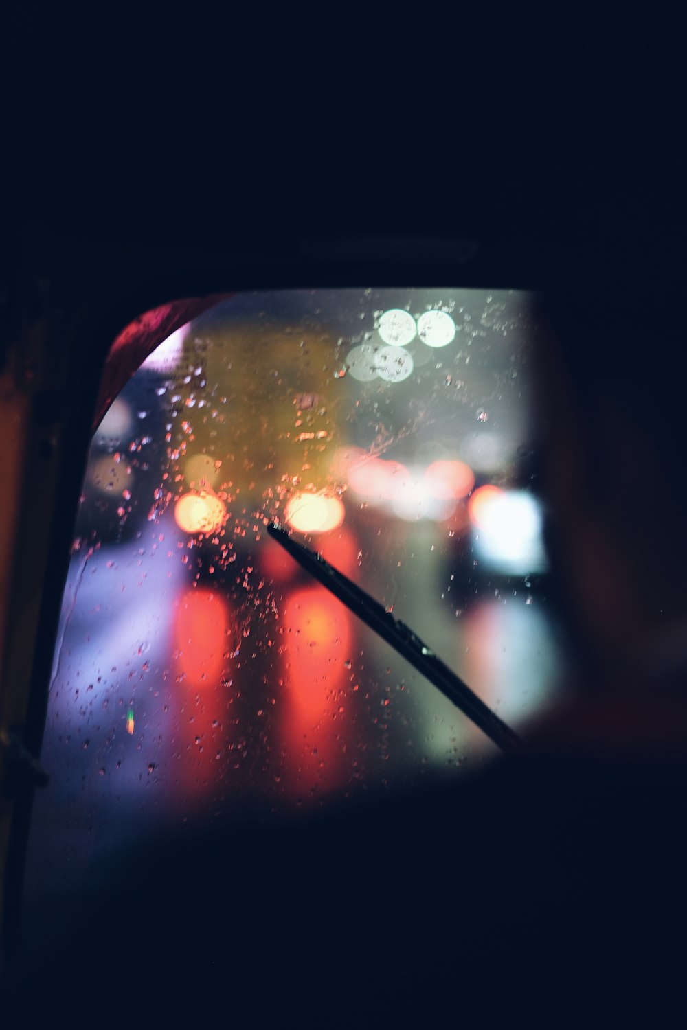 a view of a rainy street from inside a car