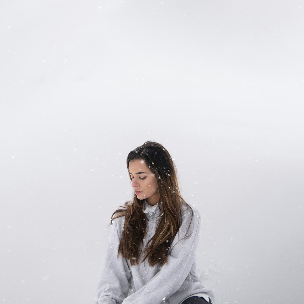 a woman sitting on a bench in the snow