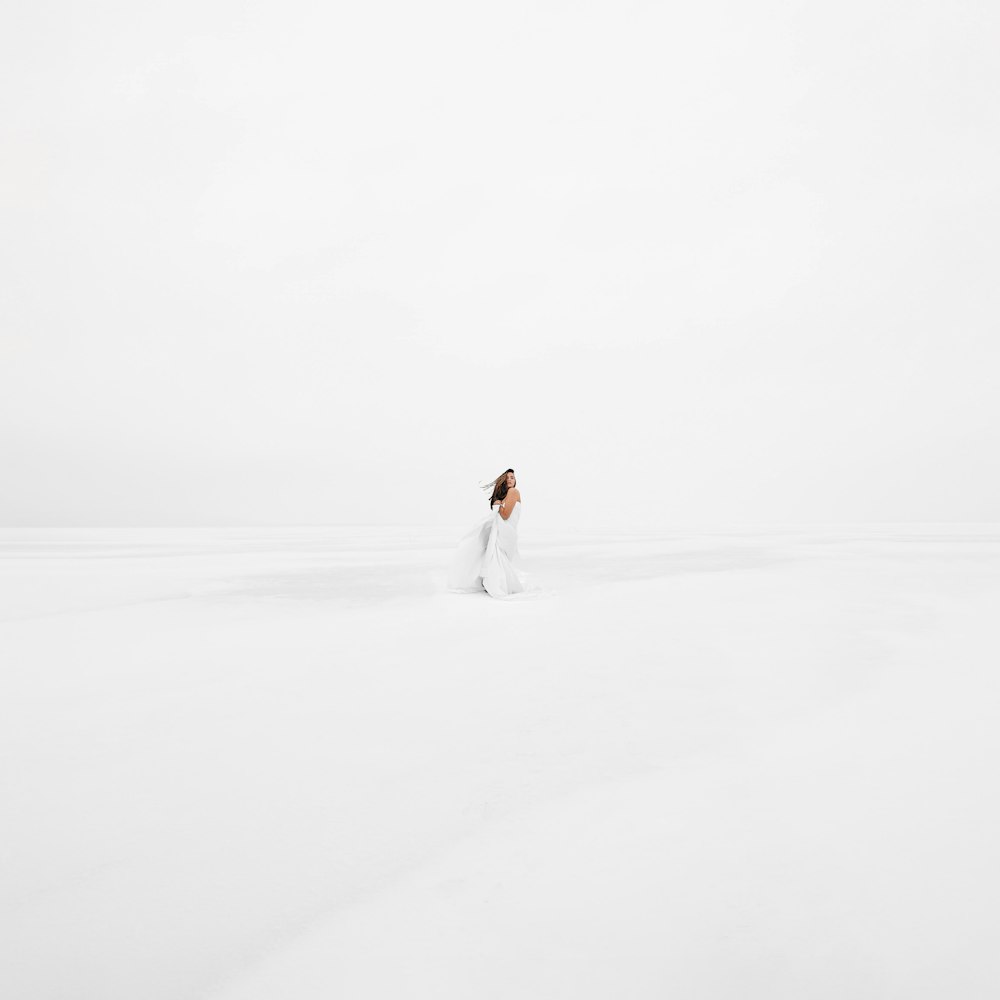 a woman standing in the middle of a snow covered field