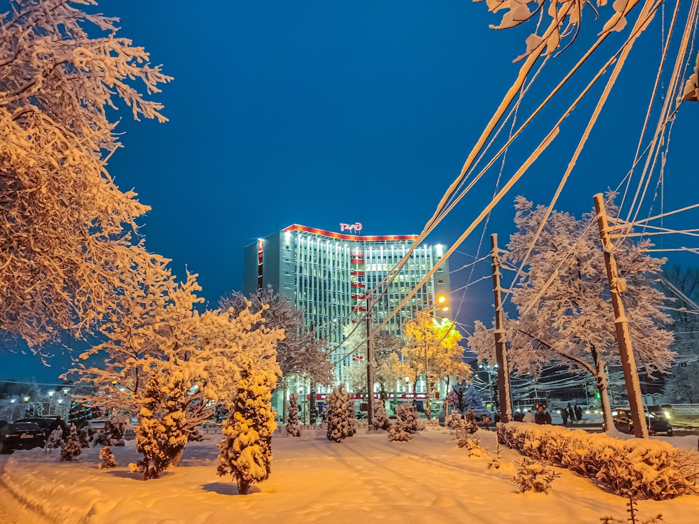 a city street covered in snow next to a tall building