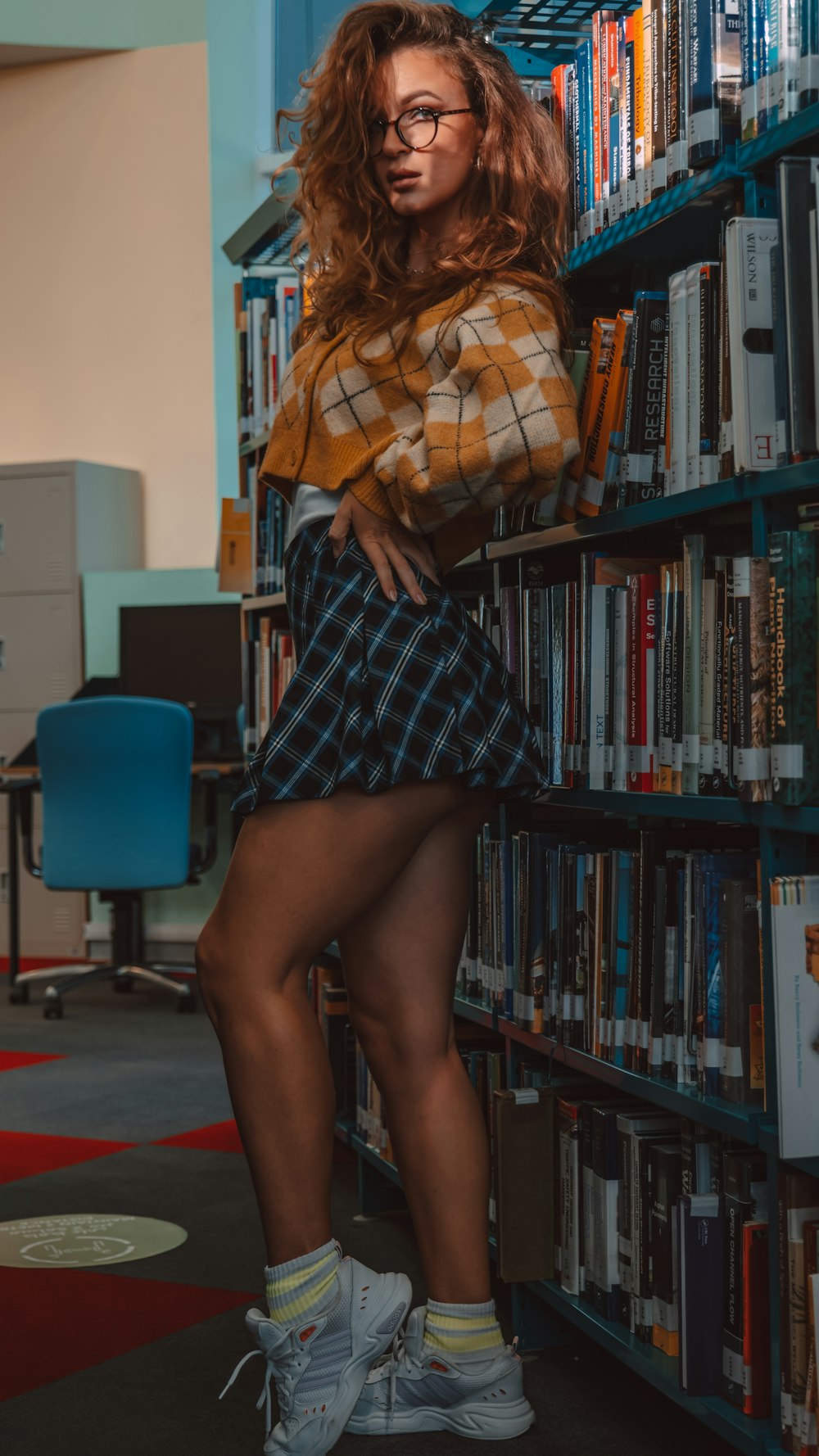 a woman standing in front of a bookshelf in a library