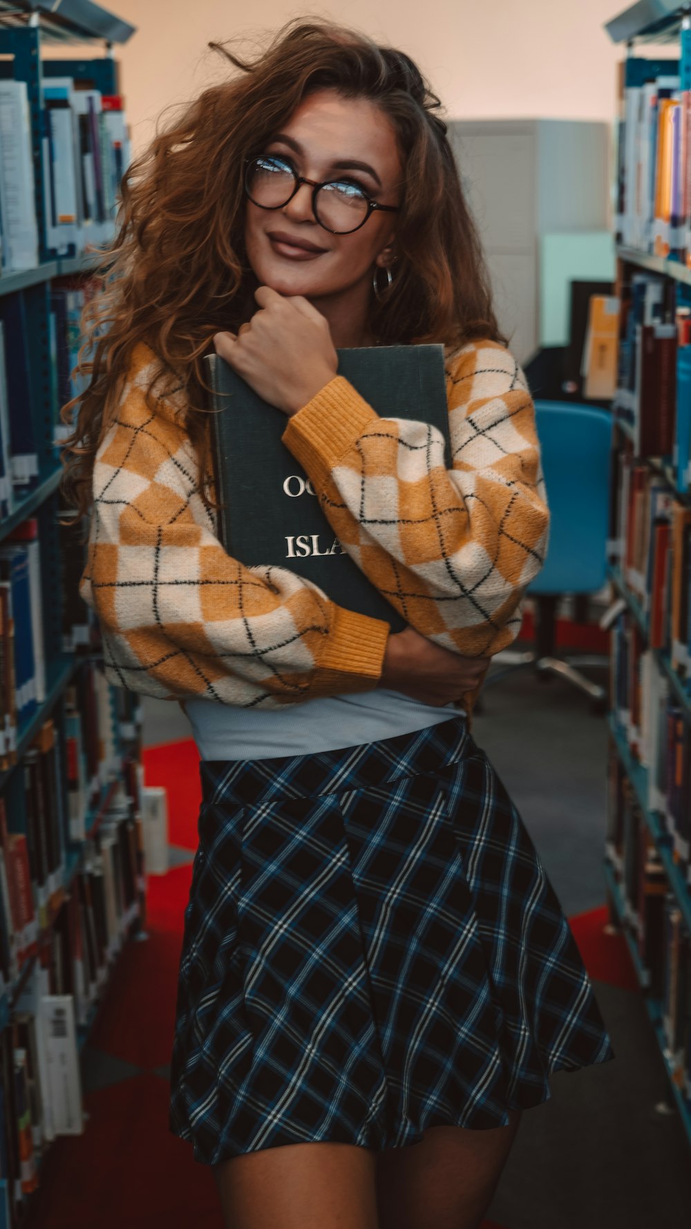 a woman standing in a library holding a book