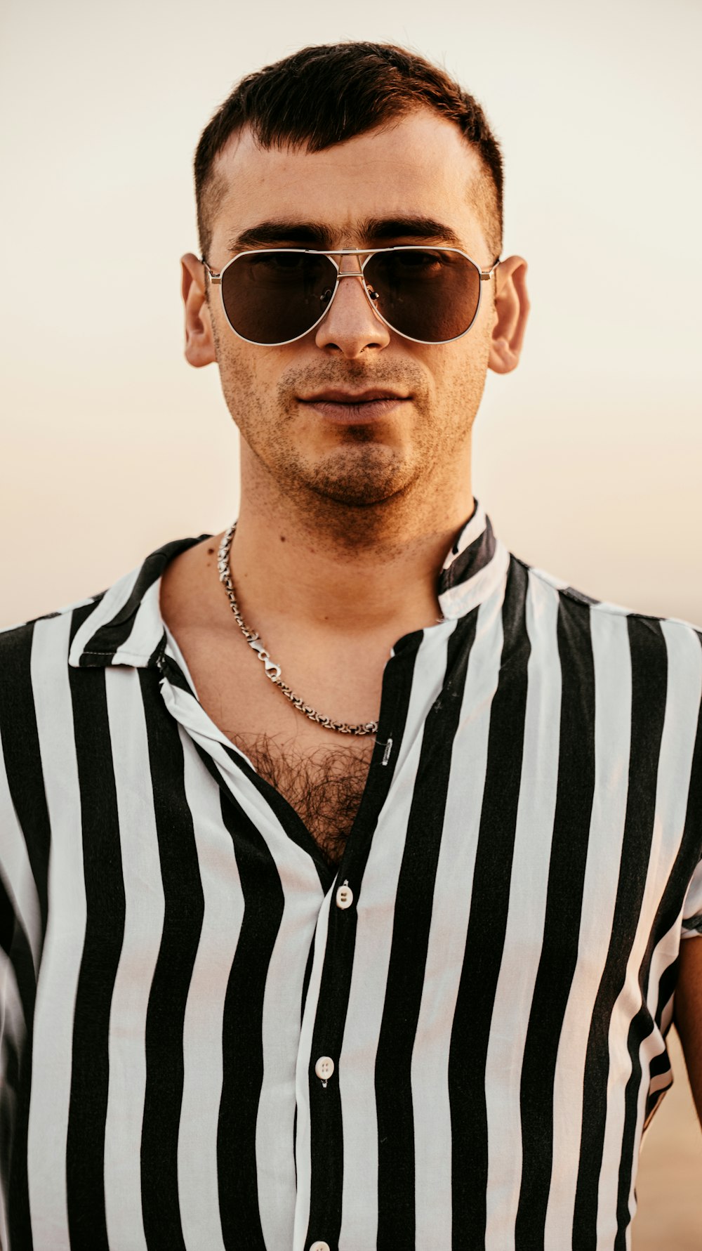 a man wearing sunglasses and a striped shirt