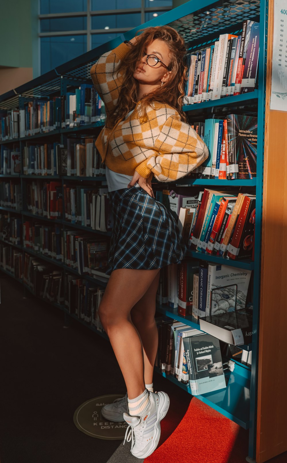 a woman standing in front of a book shelf