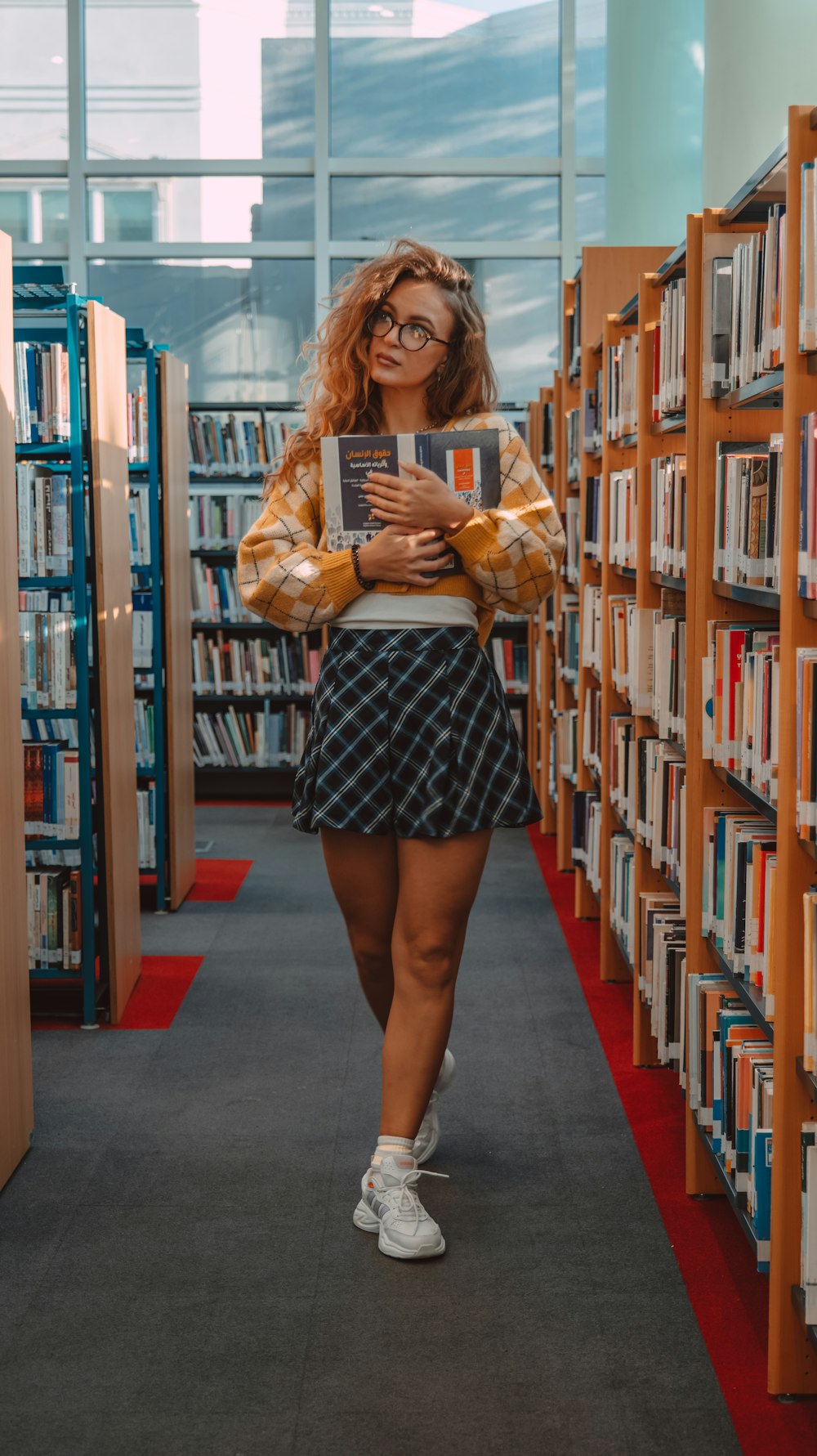 a woman in a library with a book in her hands