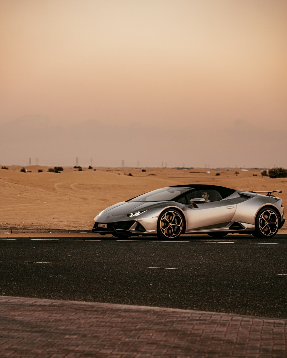 a silver sports car parked on the side of the road