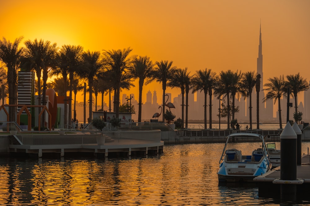 the sun is setting over the water and palm trees