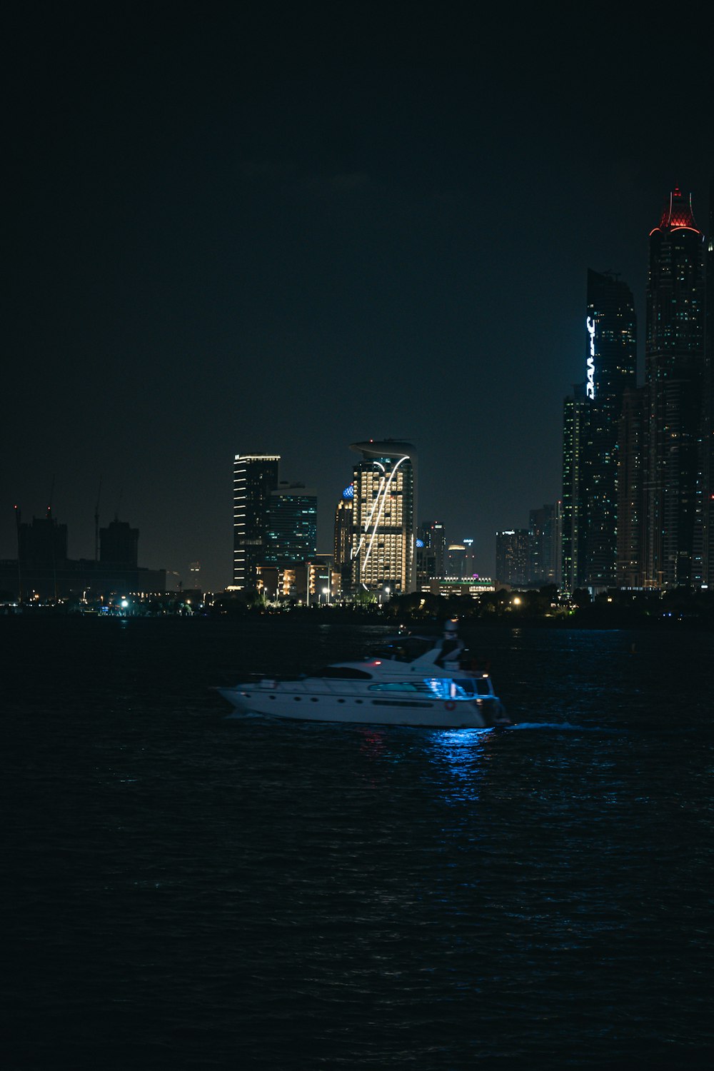 a boat in the water near a city at night