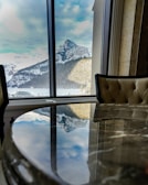 Close-up of a polished Italian marble dining table with gold accents in a sunlit luxury villa.