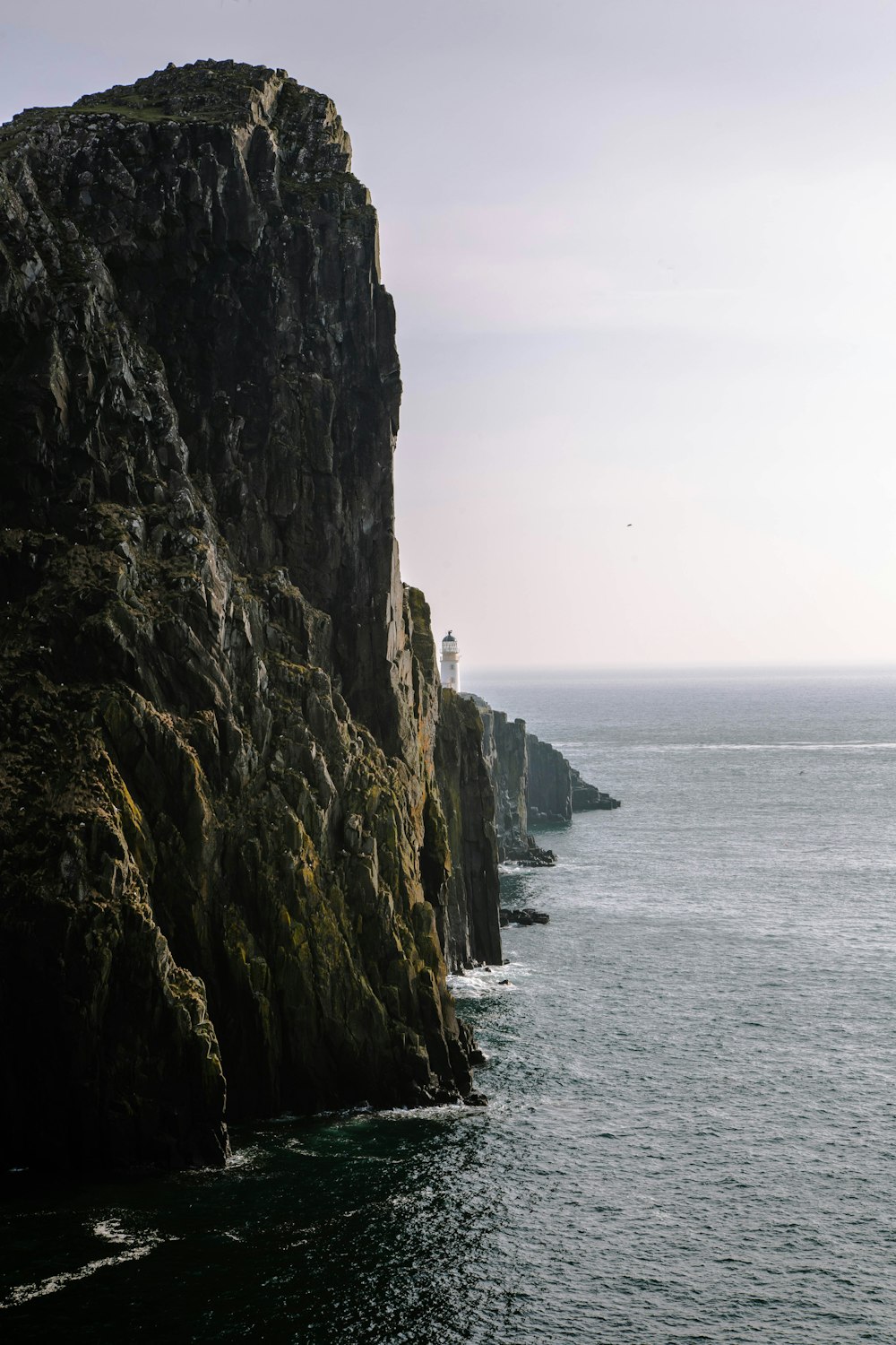 une falaise rocheuse surmontée d’un phare