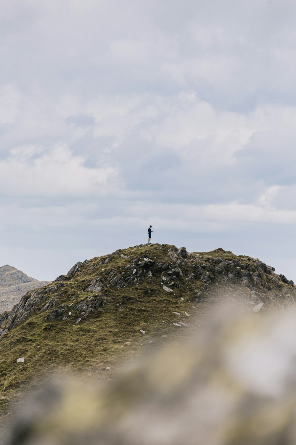 a person standing on top of a grass covered hill