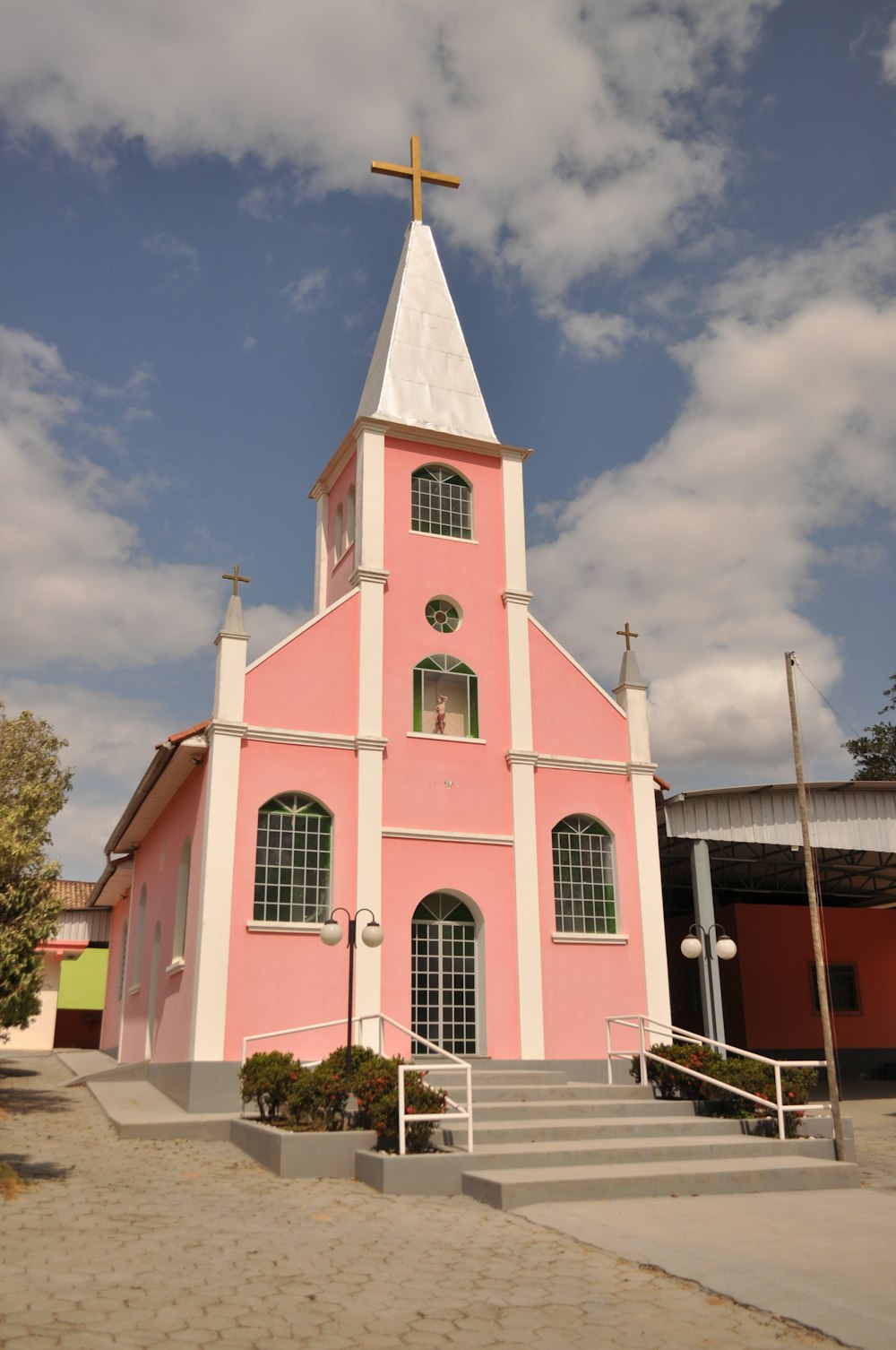 a pink and white church with a cross on top