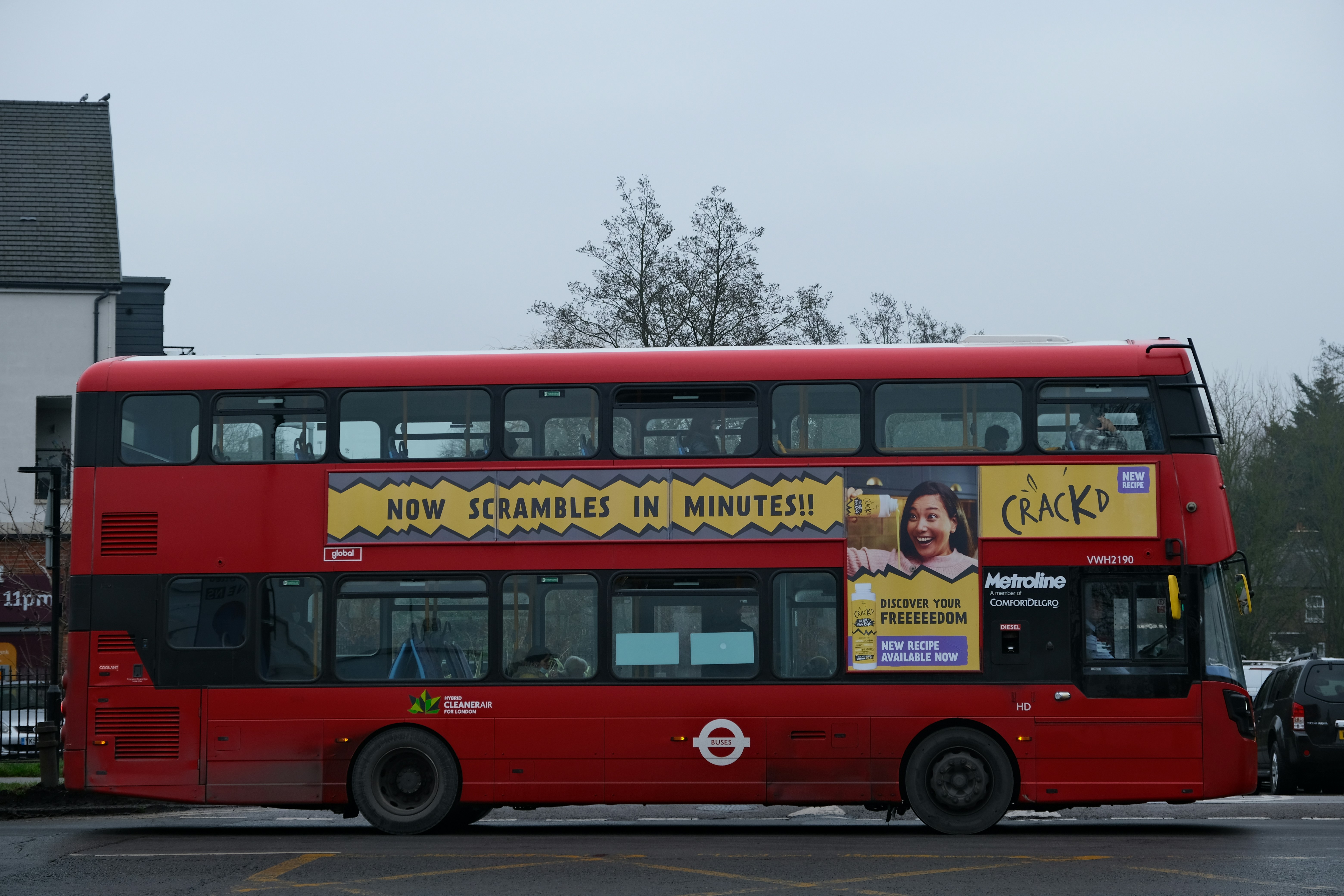 a red double decker bus parked in a parking lot
