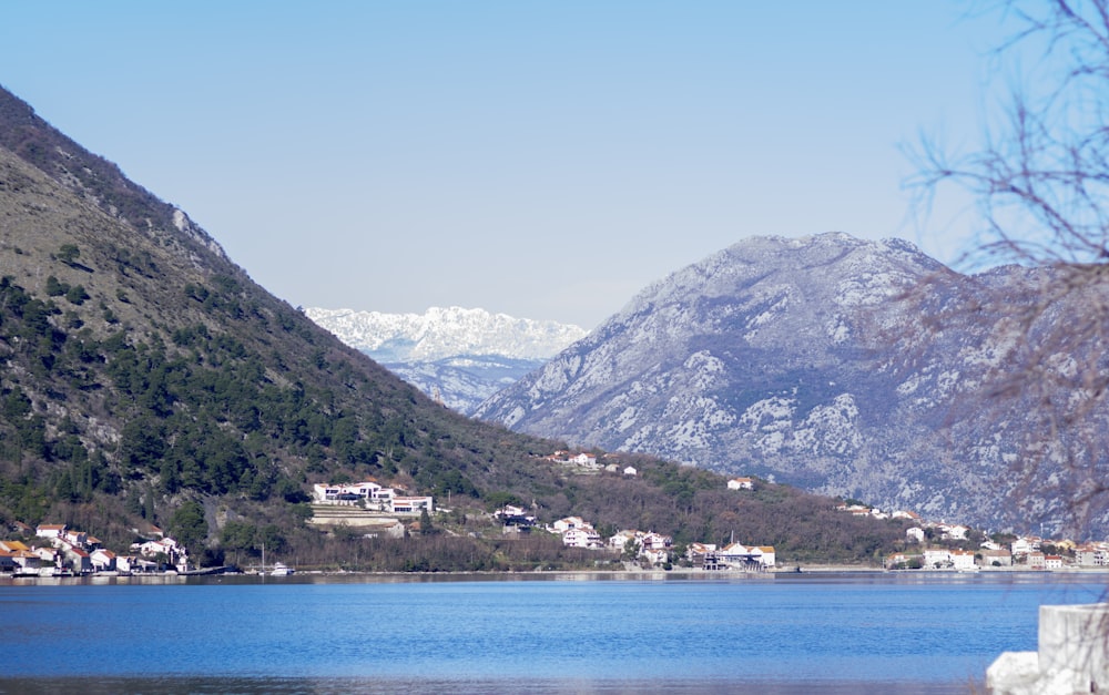 a lake surrounded by mountains with houses on it