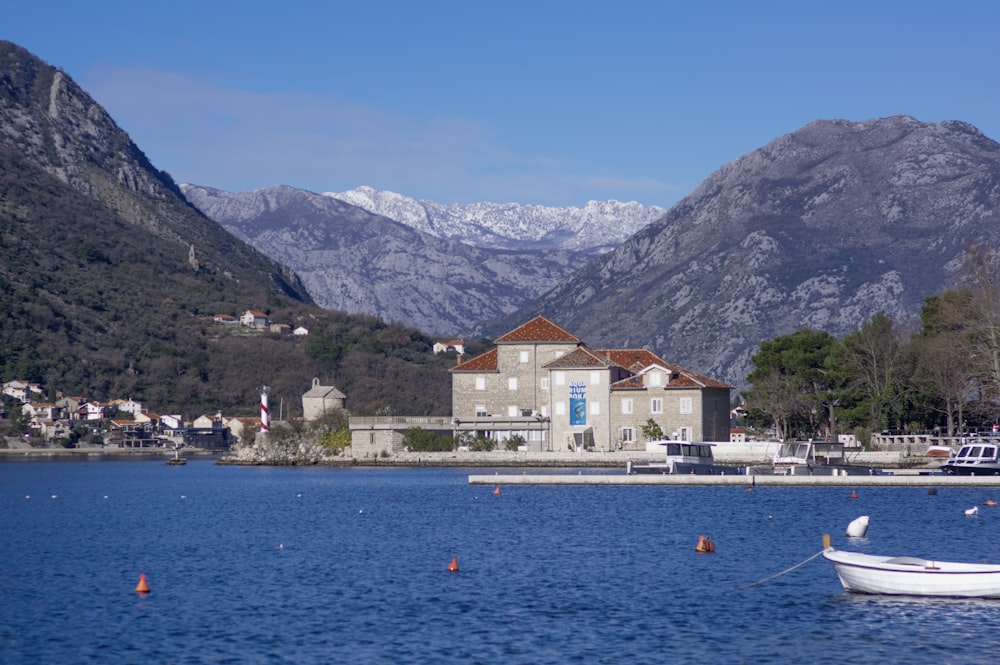 a white boat floating on top of a lake next to a mountain range