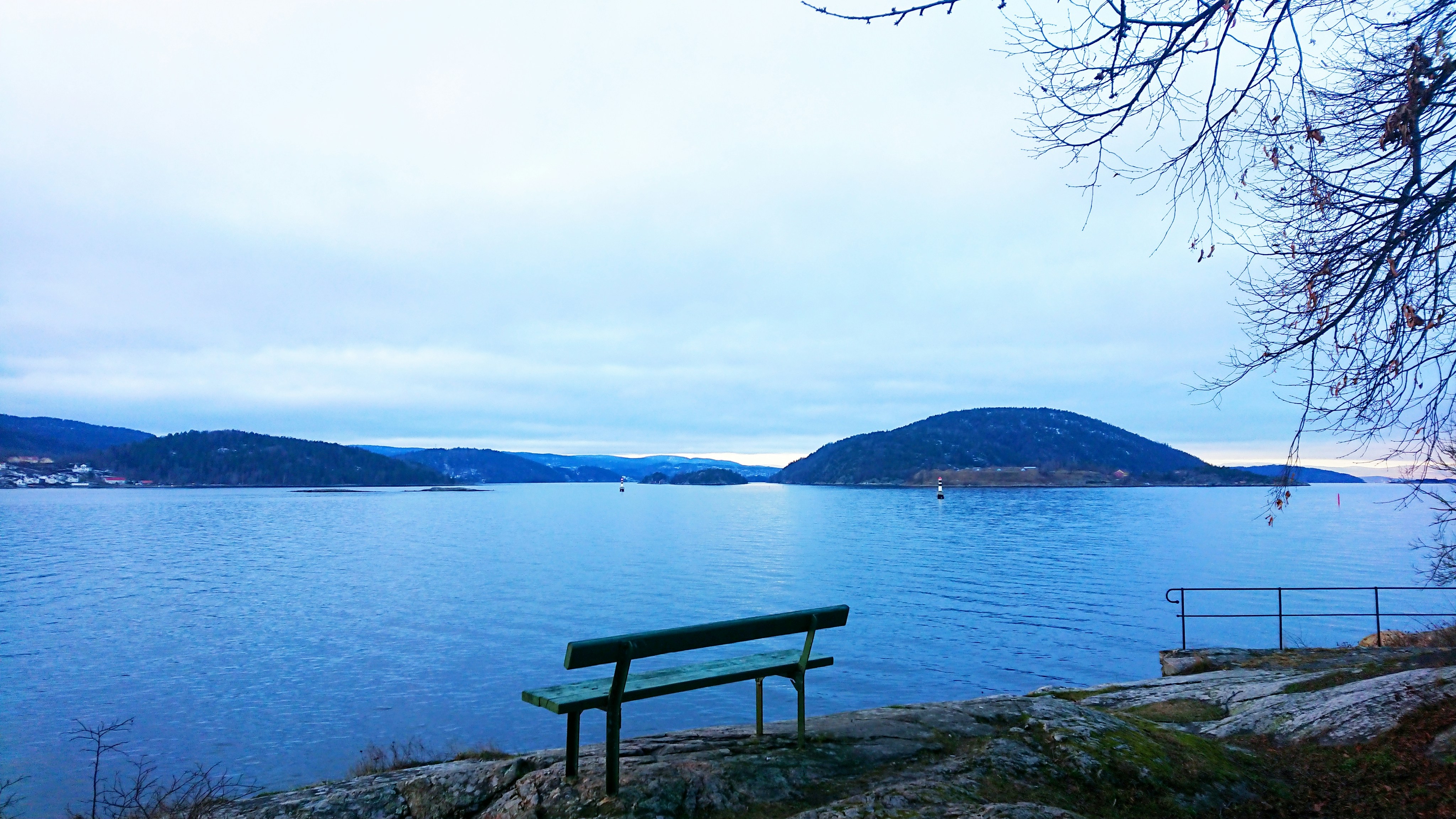 a bench sitting on the shore of a lake