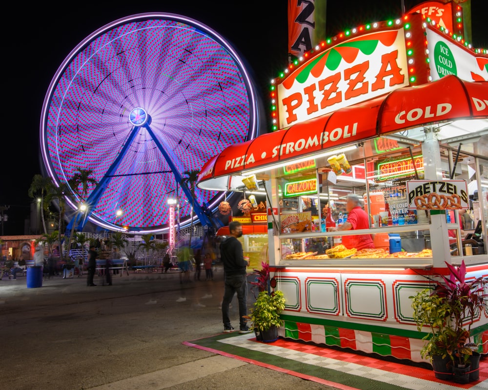 a food stand with a ferris wheel in the background