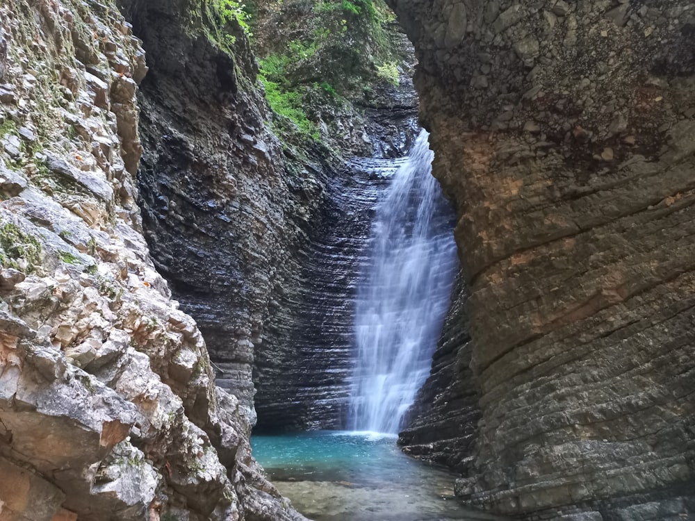 a small waterfall in the middle of a canyon