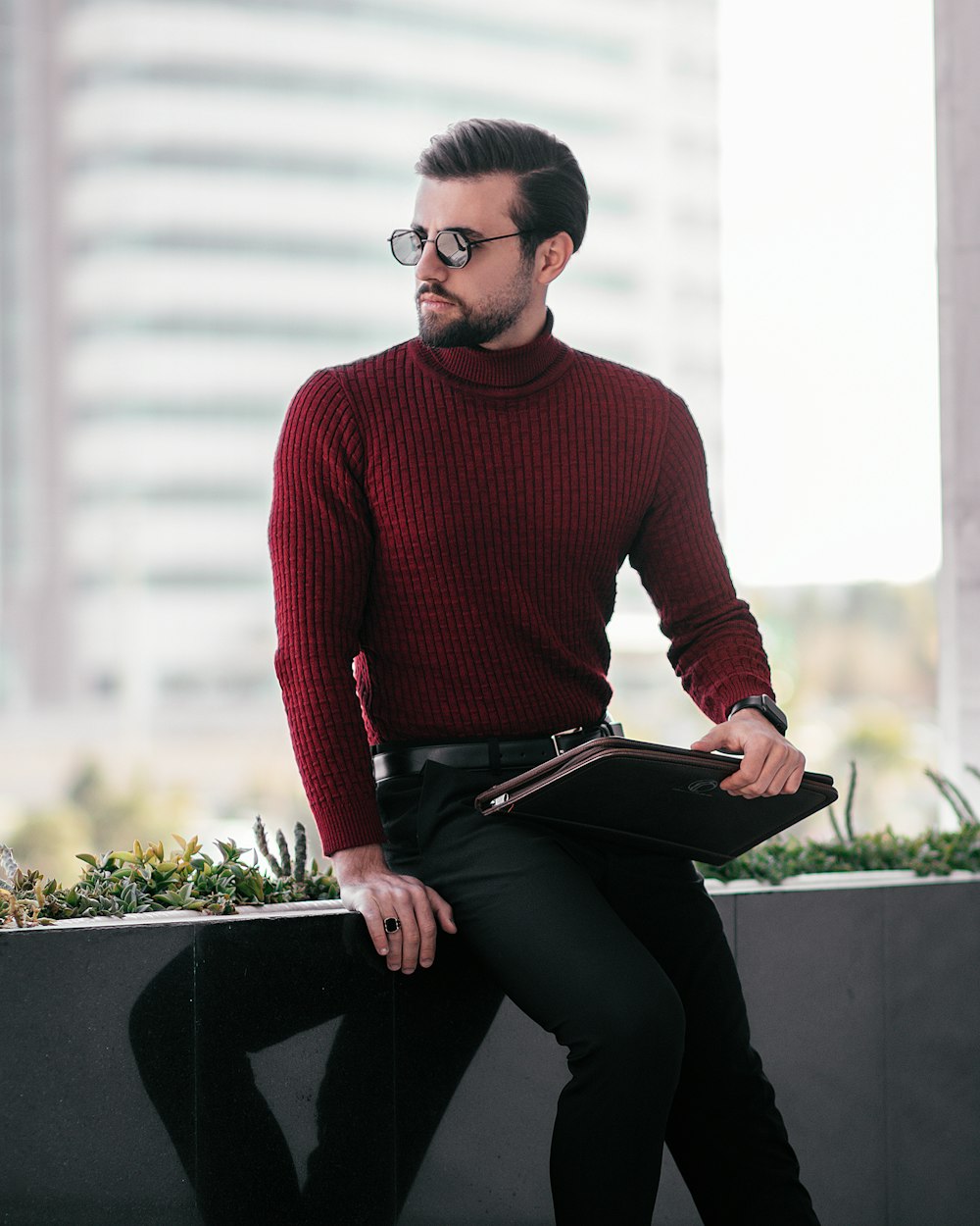 a man wearing a red sweater and black pants