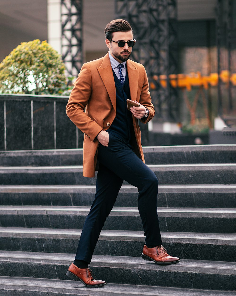 a man in a suit and tie walking down some steps