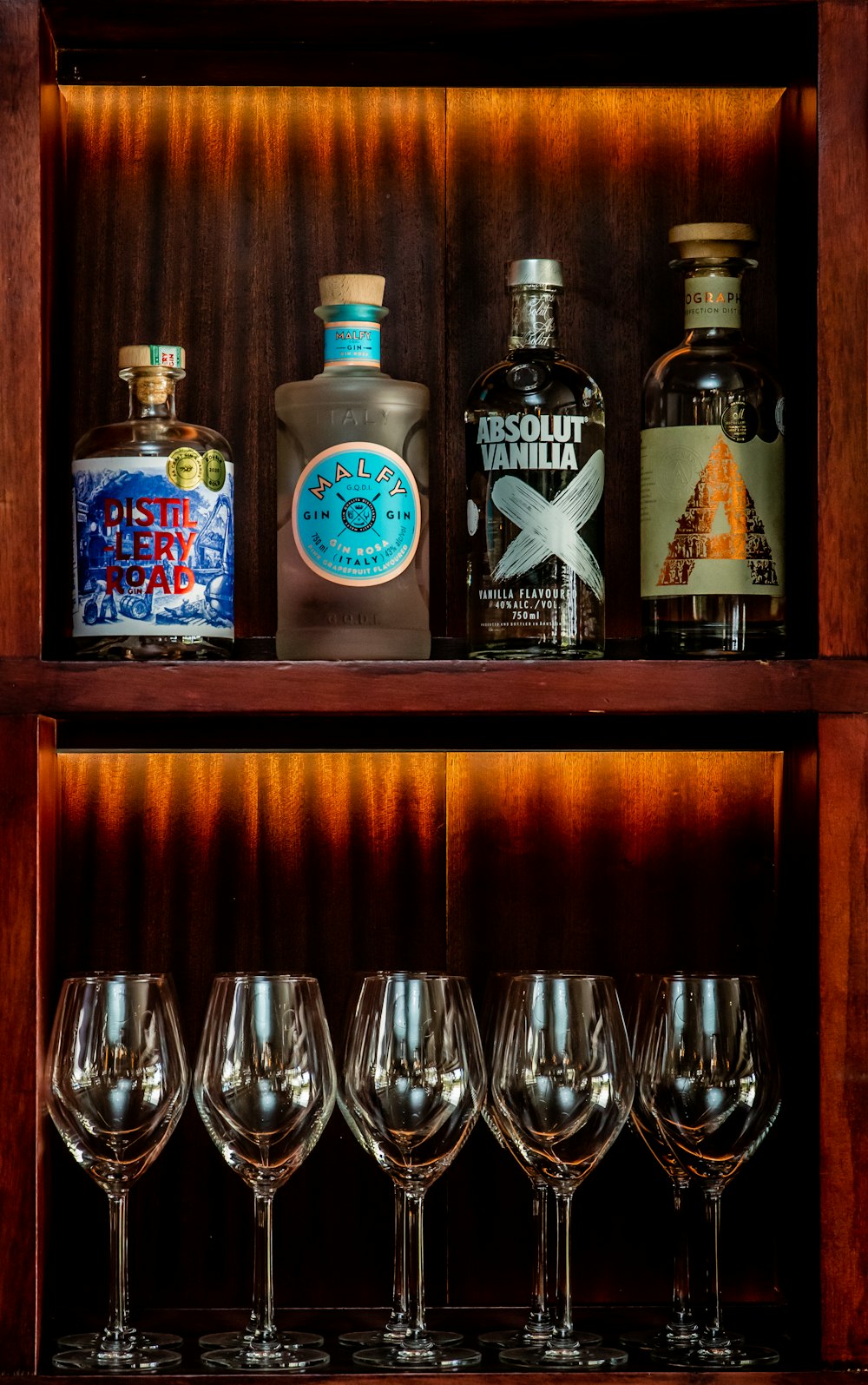 a shelf filled with wine glasses and bottles