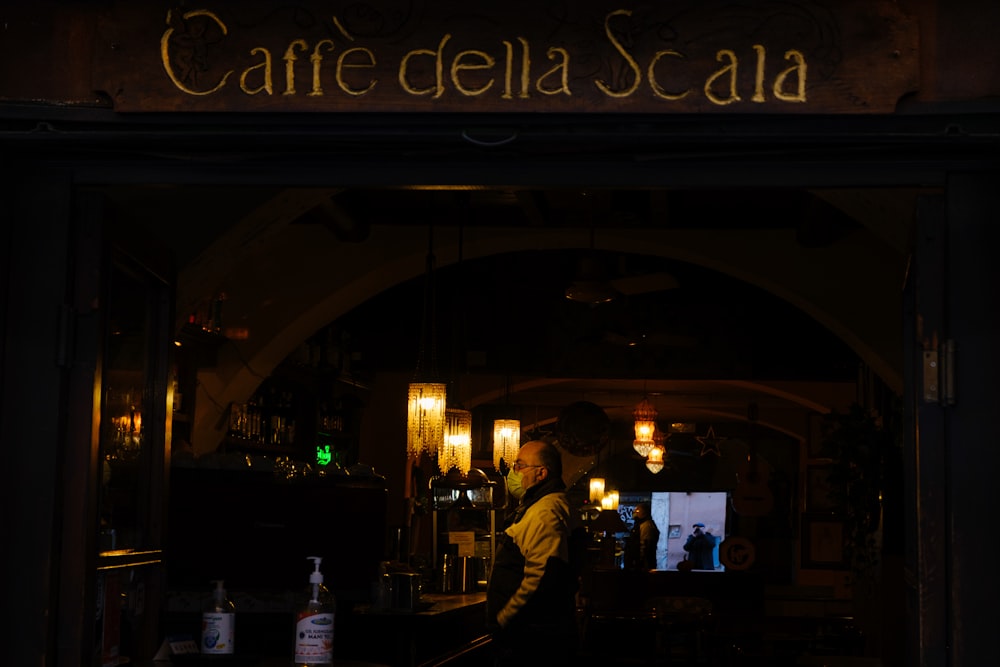 a man standing in front of a bar at night