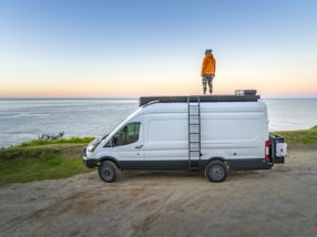 a man standing on top of a white van