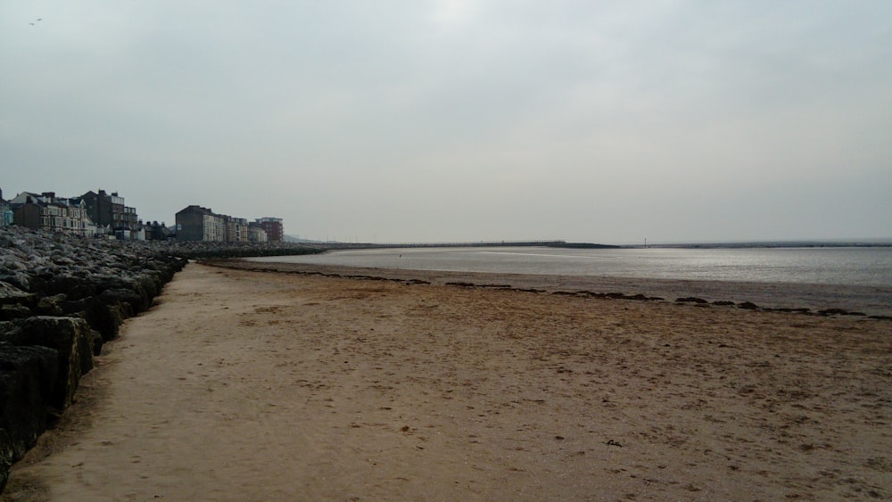 uma praia de areia ao lado de um corpo de água