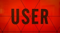 Bold, black typography spells the word 'USER' against a vibrant orange background with geometric triangular patterns.