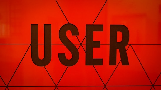 Bold, black typography spells the word 'USER' against a vibrant orange background with geometric triangular patterns.