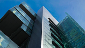 An elegant commercial building featuring clean lines and cobalt blue structural elements reflecting sunlight.