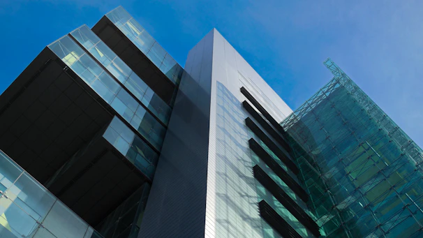 An elegant commercial building featuring clean lines and cobalt blue structural elements reflecting sunlight.