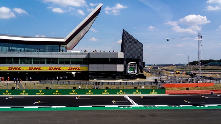 Exterior view of Interlagos Hub storefront with racing track curves in the background under a clear sky.