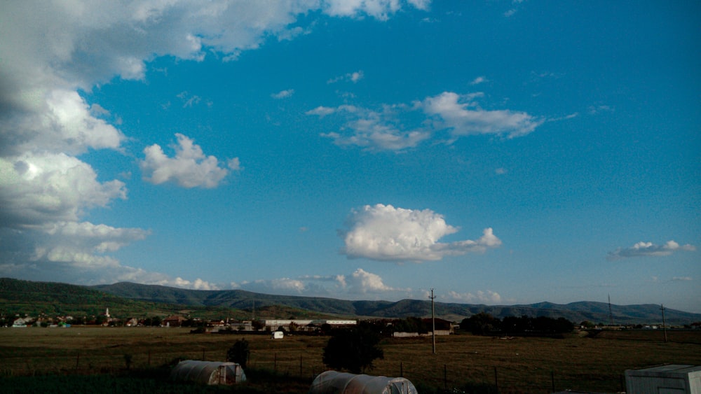 a field with a few clouds in the sky