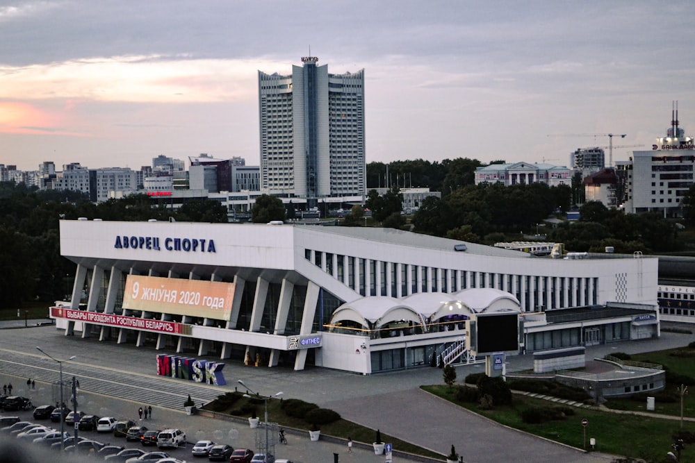 a large white building with a lot of cars parked in front of it