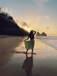 a woman standing on top of a beach next to the ocean
