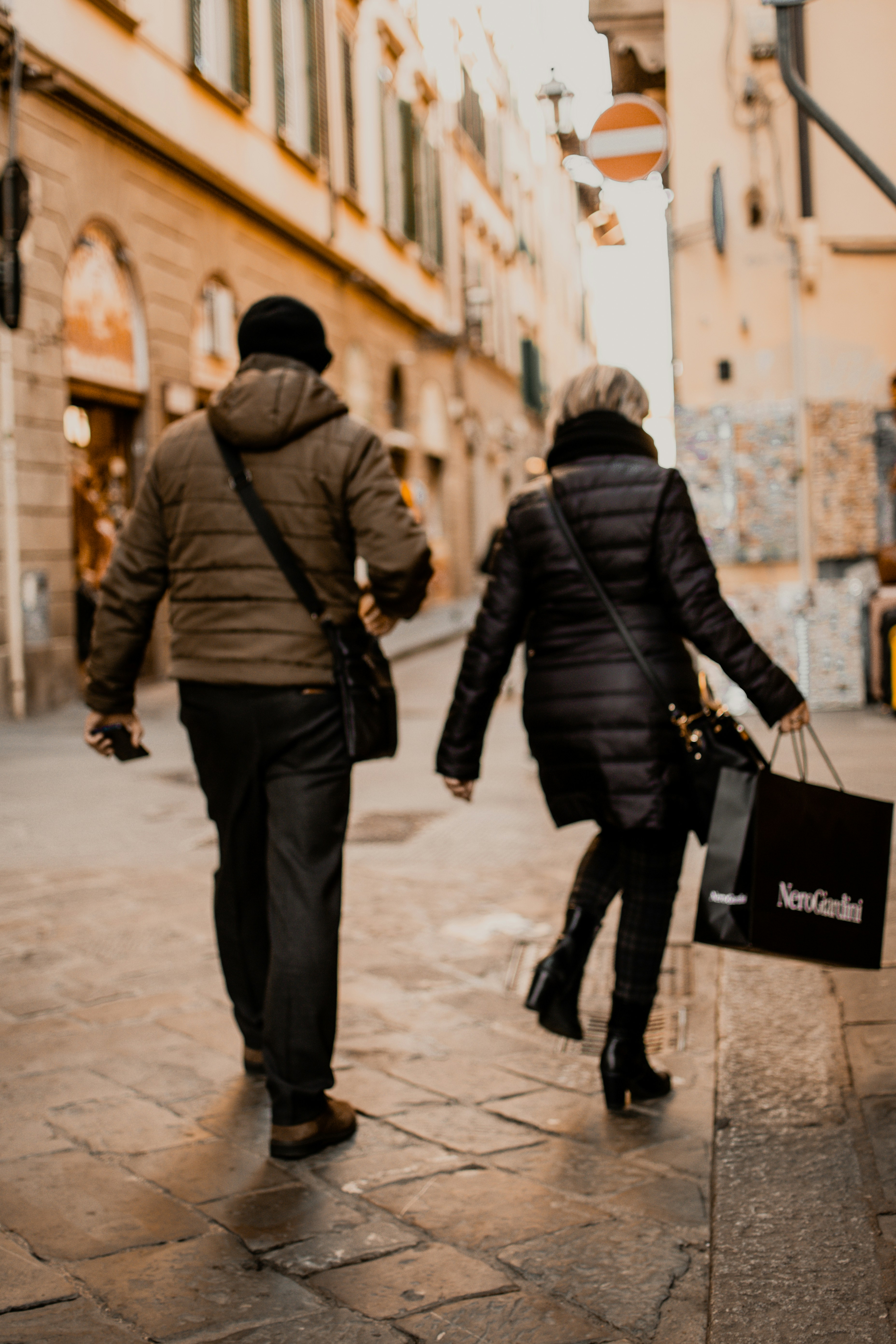 a couple of people walking down a street