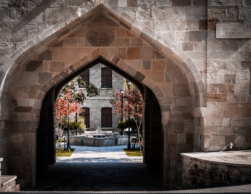 an archway leading to a building with a fountain