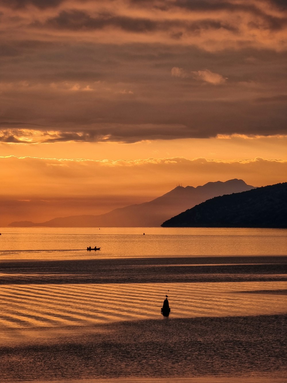 a person standing on a beach at sunset