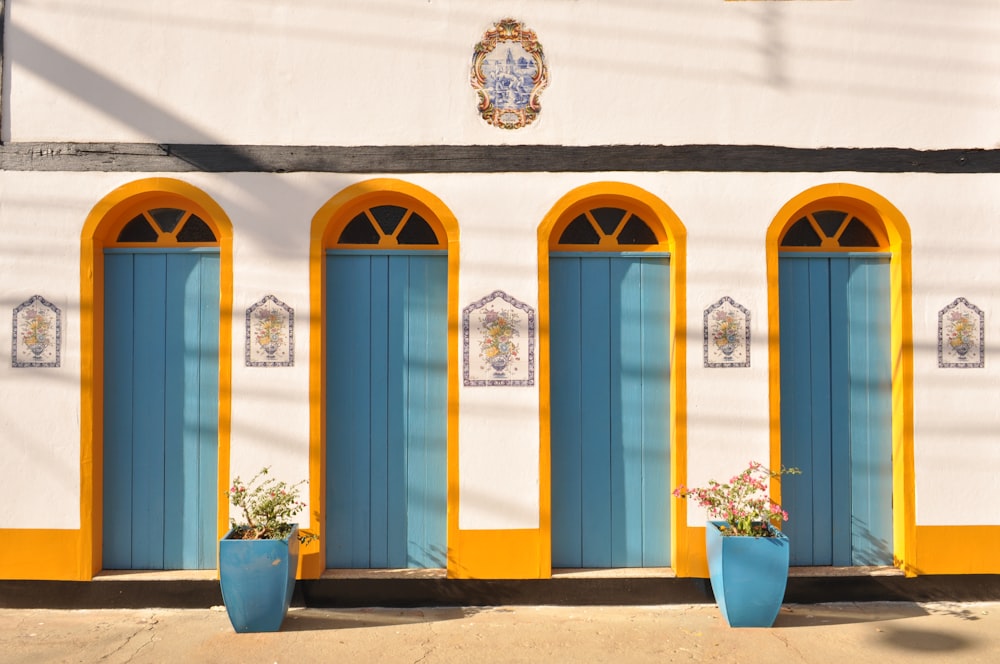 a white building with blue and yellow doors