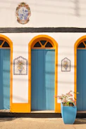 a white building with blue doors and yellow trim