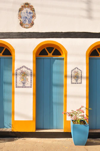 a white building with blue doors and yellow trim