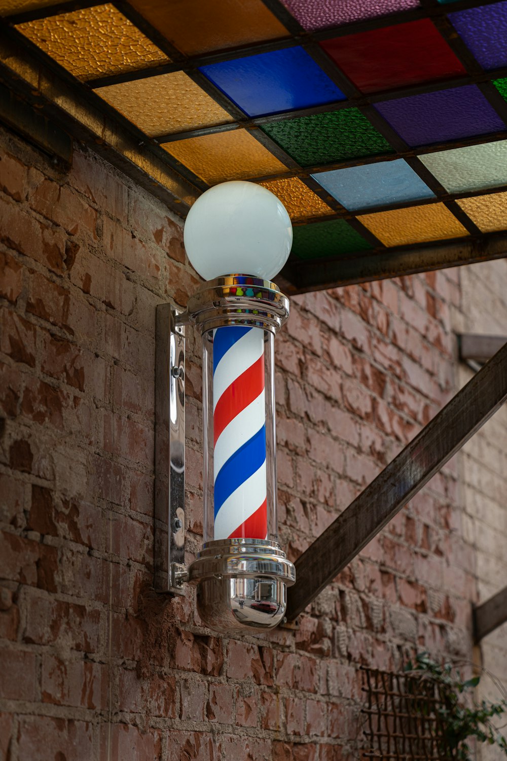 a barber pole with a colorful light on top of it
