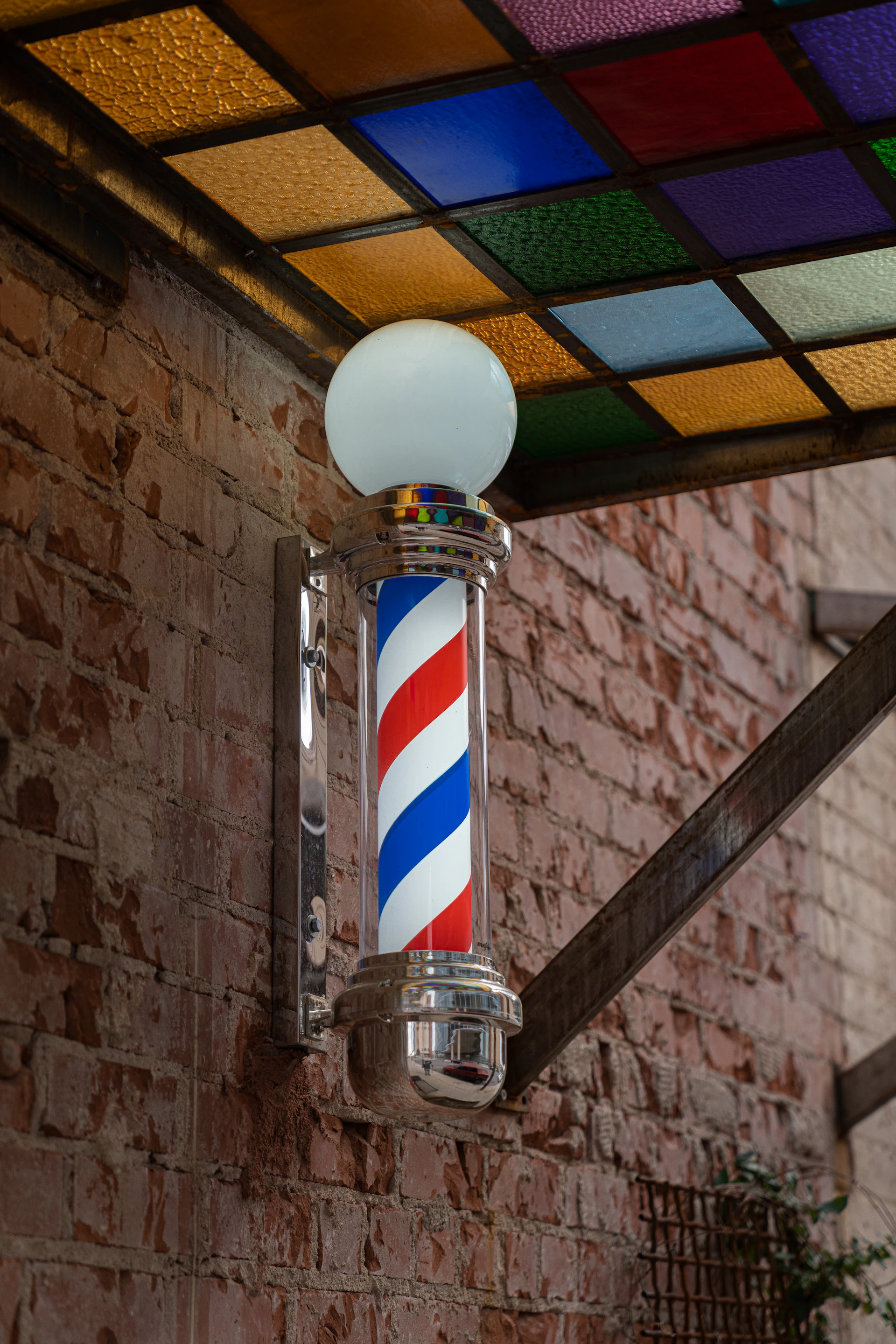 a barber pole with a colorful light on top of it