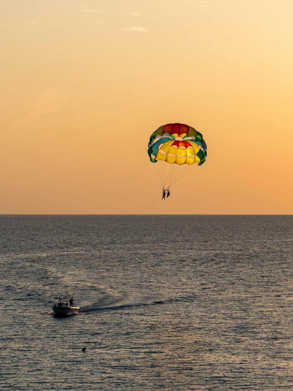 a person parasailing in the ocean at sunset